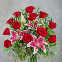 Red roses and pink lilies in a clear glass vase