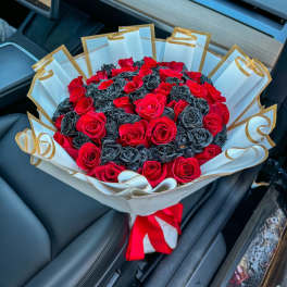 Bouquet of red roses wrapped in white paper with gold trim