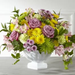 Mixed bouquet of pink roses and yellow flowers in a white vase