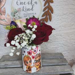Bouquet of red roses and pink flowers in a printed gift cup