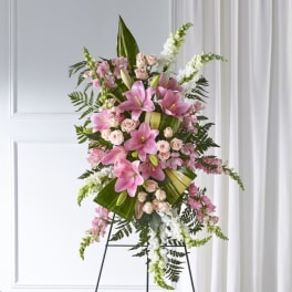 Pink lilies and roses in a standing floral spray on an easel