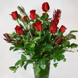 Red roses arranged in a clear glass vase
