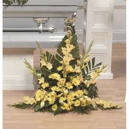 Tall yellow floral spray with palm leaves and ribbon accents