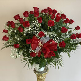 Large bouquet of red roses with baby's breath in a vase