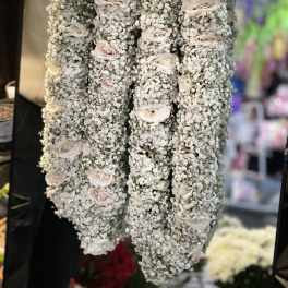 Four hanging floral garlands covered in white baby's breath with pale roses