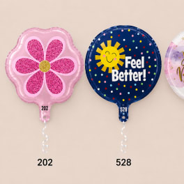 Three round foil balloons, including a pink flower and two birthday-themed designs.