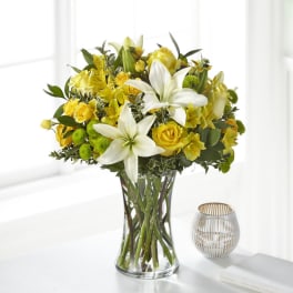 Yellow and white flower bouquet in a clear glass vase