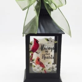 Black lantern with a green bow and a memorial bird design