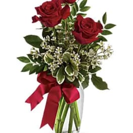 Red roses in a glass vase with a red ribbon
