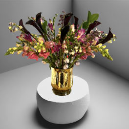 Mixed bouquet in a gold vase with pink, yellow, and dark purple flowers