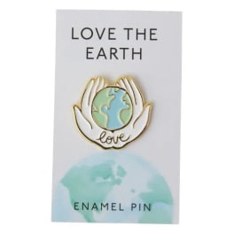 Enamel pin on a card with hands holding the Earth and the words Love the Earth
