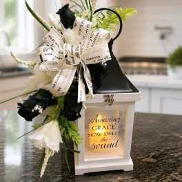 Black and white floral arrangement with a ribbon bow on a lantern