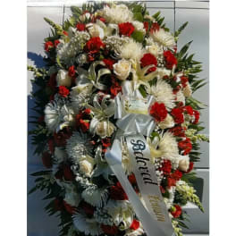 Large red and white funeral spray with ribbon on an easel