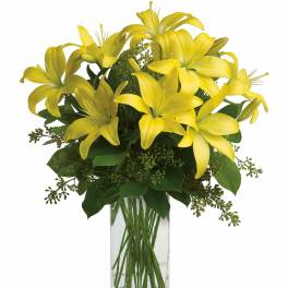 Yellow lilies arranged in a clear glass vase