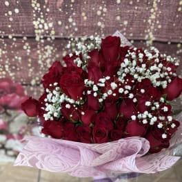Bouquet of red roses with white baby's breath in pink wrapping