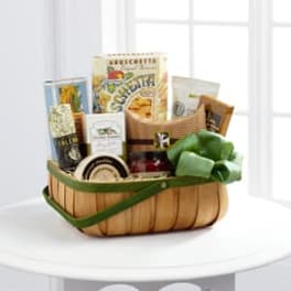 Gift basket with assorted packaged snacks and a green bow