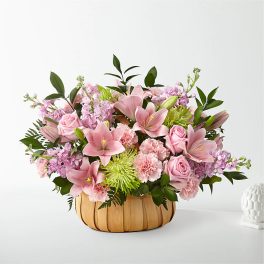 Pink lilies, roses, and carnations in a woven basket