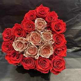 Round bouquet of red and gold roses on a dark background