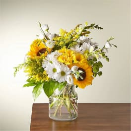 Bouquet of sunflowers and white daisies in a clear glass vase