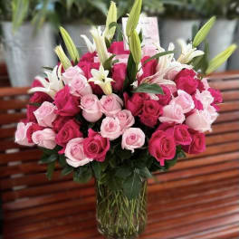 Bouquet of pink and white roses with white lilies in a glass vase