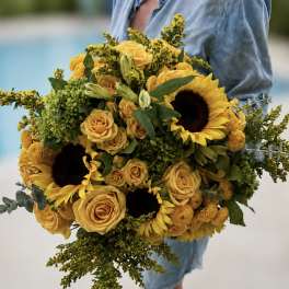 Large bouquet of yellow roses and sunflowers with green filler
