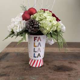 Holiday floral arrangement in a decorated vase with red ornaments and white branches