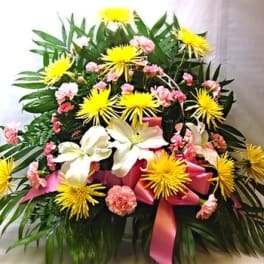 Large floral arrangement with yellow spider mums, white lilies, and pink carnations