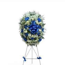 Blue and white funeral wreath on a standing easel with ribbon