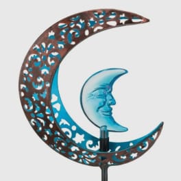 Decorative crescent moon sculpture with a blue glass moon face