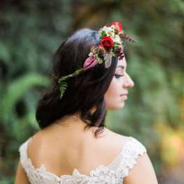 Woman wearing a floral crown with red roses and small white flowers