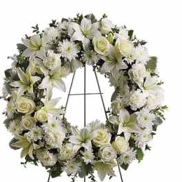 White floral wreath on a black easel stand