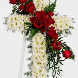 Standing cross of white chrysanthemums with red roses and carnations on an easel