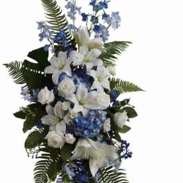 White lilies and blue flowers on a standing easel spray
