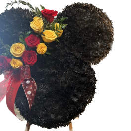 Mouse-ear shaped black floral wreath with red and yellow roses and a red MOM ribbon.