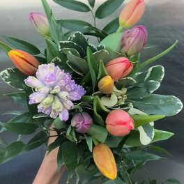 Handheld bouquet of tulips and a purple hyacinth cluster