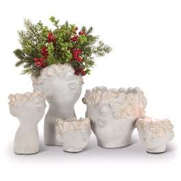 Five white floral face planters, one filled with evergreen and red berries