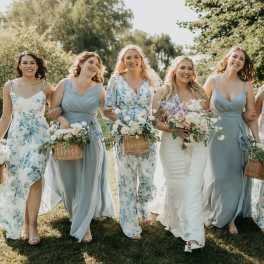 Bridal party walking outdoors with pastel bouquets and wicker baskets