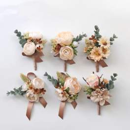 Six small wedding boutonnieres with cream flowers and brown ribbons