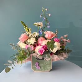 Pink and white mixed flower arrangement in a decorative box