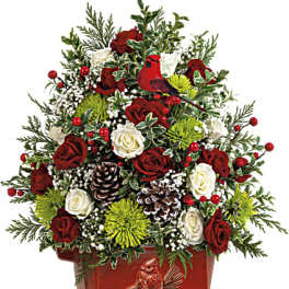 Holiday floral arrangement with red and white roses in a red container