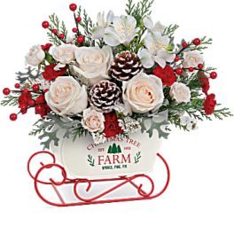 Christmas bouquet with white roses and red berries in a sleigh container