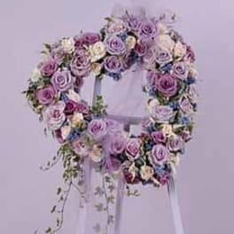 Lavender and white rose wreath on a white stand