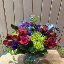 Colorful bouquet in a clear glass vase with roses, chrysanthemums, and alstroemeria
