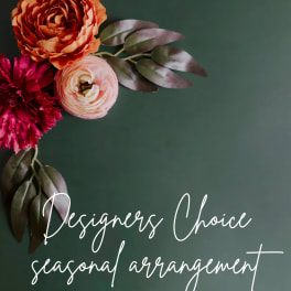 Floral arrangement with orange, pink, and magenta blooms on a dark green background