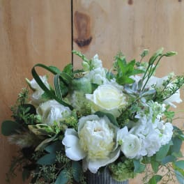 White floral arrangement in a dark ribbed vase