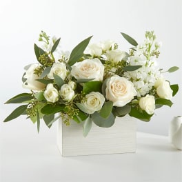 White roses and white blooms arranged in a white box