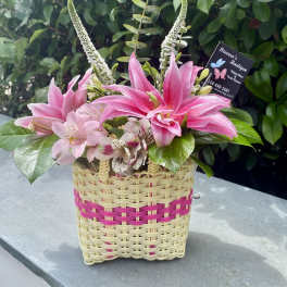 Pink lilies and alstroemeria in a woven basket