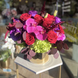 Bouquet of red roses and pink orchids in a glass vase