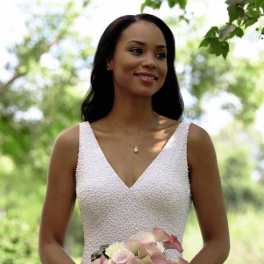 Bride holding a bouquet of pale pink and white flowers with dark accents