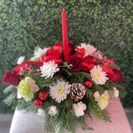 Holiday centerpiece with red candle, roses, and white flowers